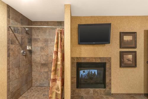 a bathroom with a fireplace and a television on a wall at Best Western Plus Kelly Inn and Suites in Fargo