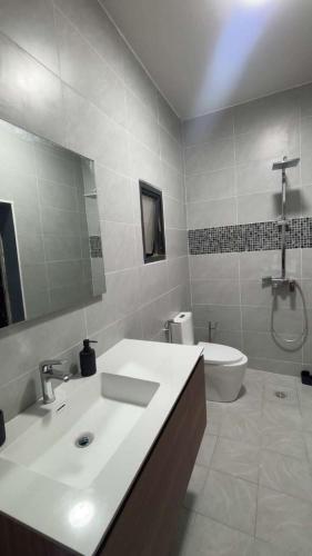 a bathroom with a sink and a tub and a toilet at Résidence LE MÄYSA CORAIL in Sada