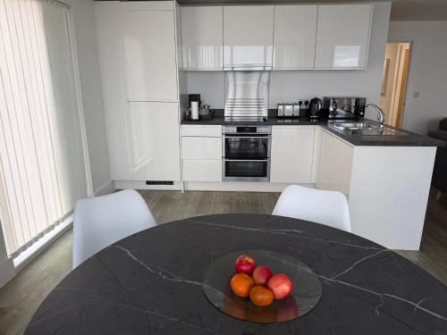 a kitchen with a table with a bowl of fruit on it at Seaview West Coast - Exceptional - 2 Bedrooms Sleeps 5 -Stunning Sea Views - 500 metres to Beach in Bournemouth