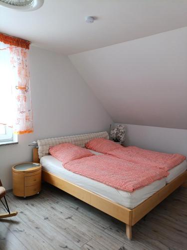 a bedroom with a bed with red sheets and a window at Modern Doppelhaus in Baunatal