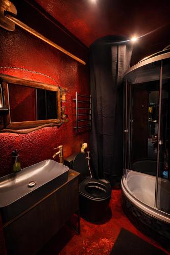 a red bathroom with a toilet and a bath tub at Netri SPA in Zofʼyuvka