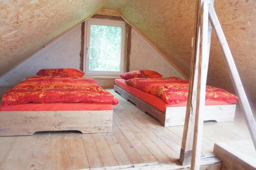 2 Betten in einem Schlafzimmer im Dachgeschoss mit Fenster in der Unterkunft Ferienhaus Bonn in Bonn