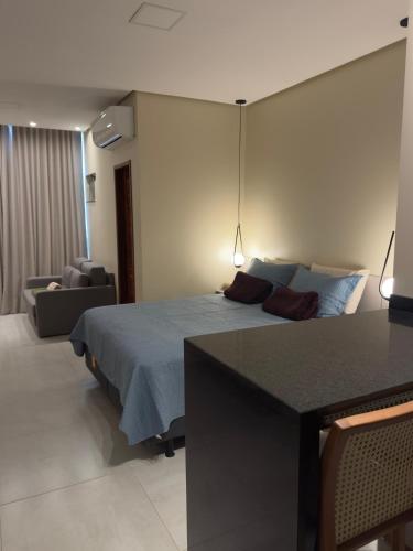 a bedroom with a bed with a table and a couch at Flat em Alter do Chão in Alter do Chao