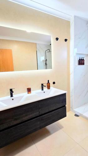 a bathroom with a white sink and a mirror at Villa Laranja-Limao in Azeitao