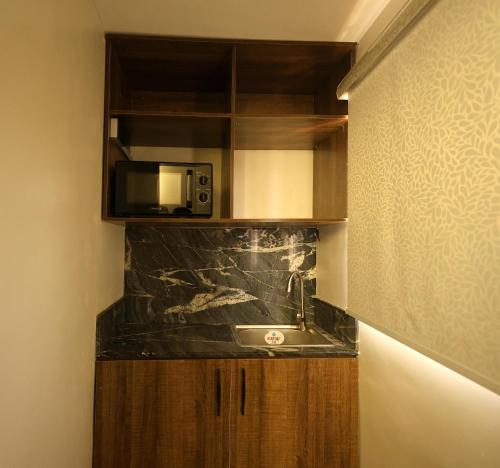 a kitchen with a sink and a microwave at Five Clover Hotel, Ilupeju in Lagos