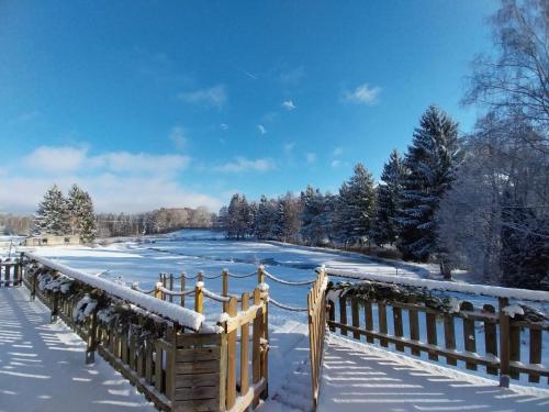 a bridge over a river in the snow at Gîte Sous le marronnier jusqu'à 10 personnes in Hadol