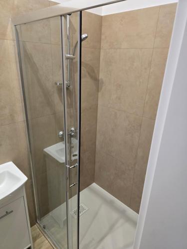 a shower with a glass door in a bathroom at Rent0nline Brwinow Rooms in Brwinów