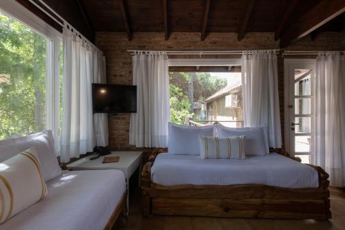 a bedroom with two beds and a large window at Carilo Village Apart Hotel & Spa in Carilo
