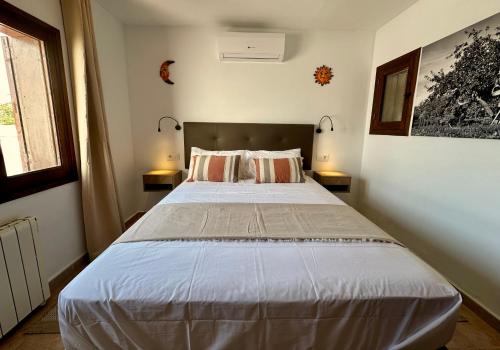 a bedroom with a large white bed with two lamps at ArteVida Andalusia FKK Nudist Holiday with yoga and massage in Mojácar
