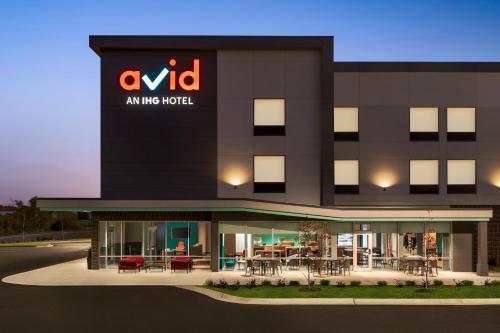 an msg hotel with tables and chairs in front of it at avid hotels - Memphis - Southaven by IHG in Southaven