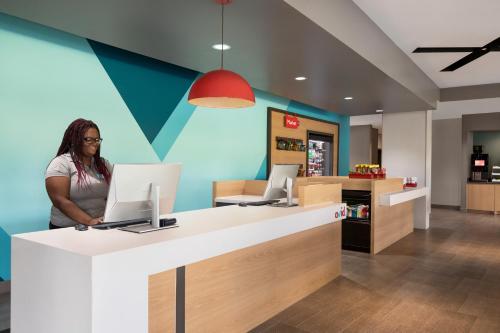 a woman standing at a desk with a laptop at avid hotels - Memphis - Southaven by IHG in Southaven