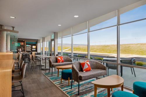 a restaurant with chairs and tables and large windows at avid hotels - Memphis - Southaven by IHG in Southaven