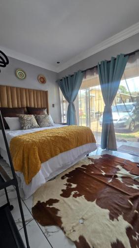 a bedroom with a large bed with blue curtains at HUZULA Royal Residence in Empangeni