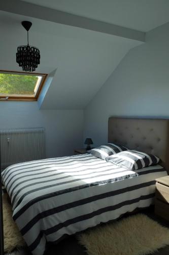 - une chambre dotée d'un lit avec une couverture rayée noire et blanche dans l'établissement Les Sources de Saverne, à Saverne