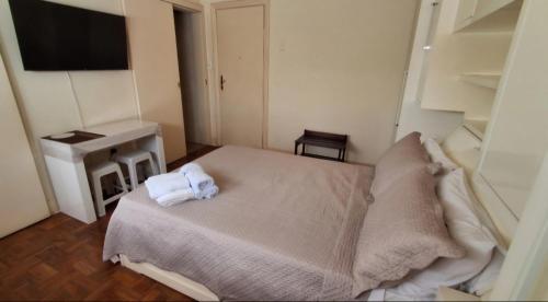 a small bedroom with a bed and a desk at Recanto da Serra Imperial in Lambari