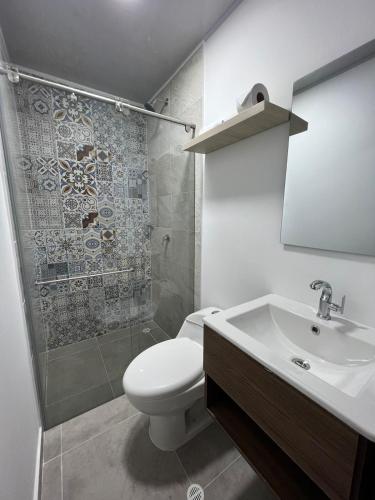 a bathroom with a toilet and a sink and a shower at Hotel Fenix in Ocaña