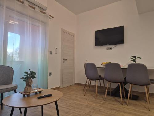 a living room with a table and chairs and a tv at Apartman Meghan in Pula