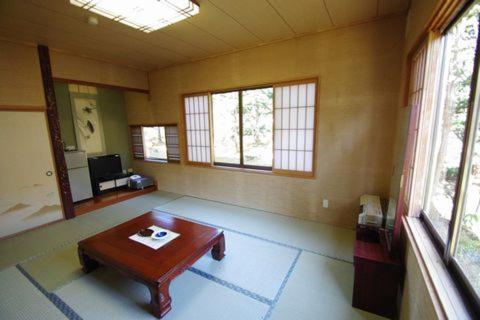 a room with a table in the middle of a room at Suzuki Ryokan in Noboribetsu