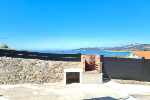 a stone wall with a bench on top of it at Casa CAMPELO- Playas de Pinténs - CANGAS-HIO- Ría de Aldán in Cangas de Morrazo