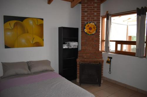 a bedroom with a bed and a painting on the wall at Loft-style cabin in Avandaro in Valle de Bravo