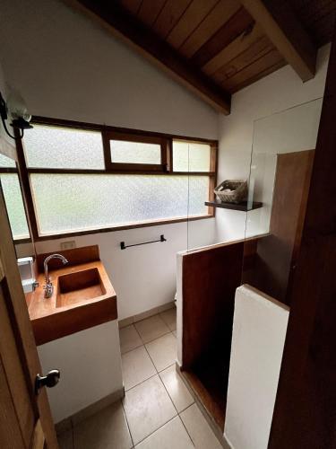a bathroom with a sink and a glass shower at Loft-style cabin in Avandaro in Valle de Bravo