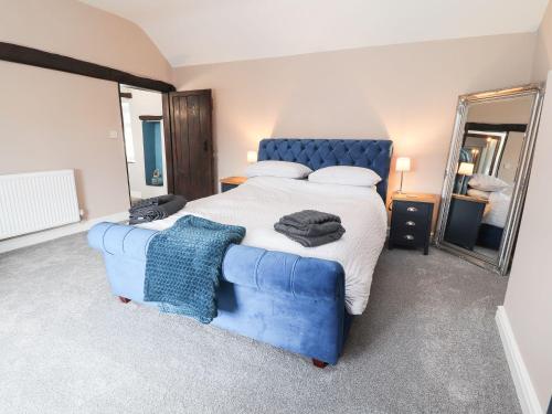 a bedroom with a large bed and a blue couch at Cae Adar Farm in Wrexham