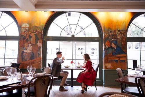 a man and woman sitting at a table in a restaurant at Maison Dupuy Hotel in New Orleans
