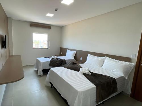 a bedroom with two beds and a window at Sun Route Hotel in Cabo de Santo Agostinho