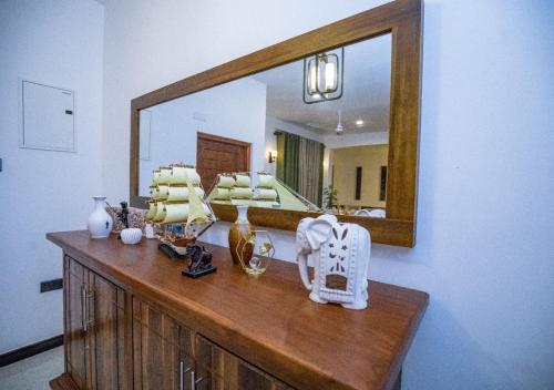 a dresser with a mirror on top of it at Villa Freedom Hikkaduwa in Hikkaduwa