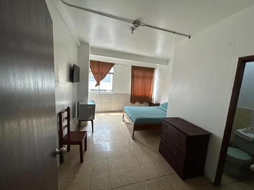 a bedroom with a bed and a chair in a room at Hotel luque in Guayaquil