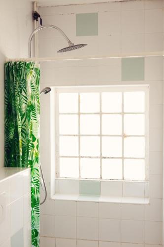 a shower curtain in a bathroom with a window at HOTEL RESTAURANT LA COTE REVEE in Leucate