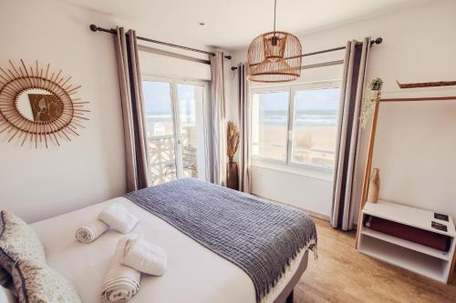 a bedroom with a bed and a large window at HOTEL RESTAURANT LA COTE REVEE in Leucate