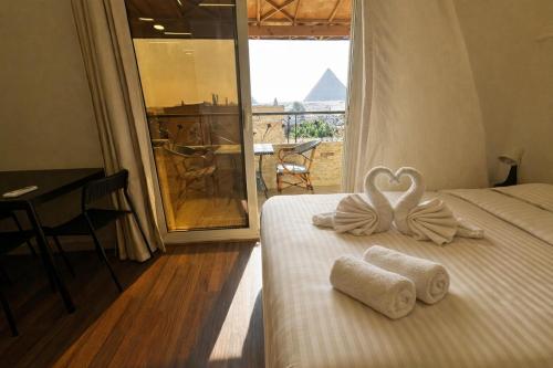a bedroom with two beds with towels in the shape of a heart at Narmer Pyramids View in Cairo