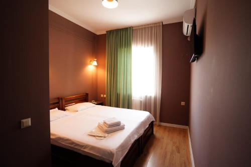 a bedroom with a bed with towels on it at Hotel Maisis Ezo in Kutaisi