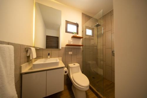a bathroom with a toilet and a sink and a shower at Designer Villa with Direct Pool Access in Monterrico