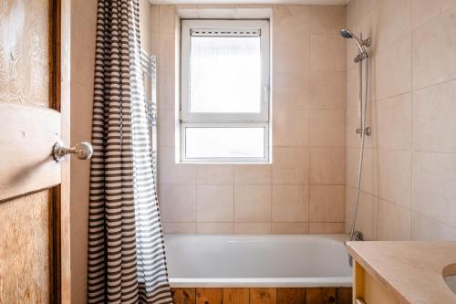 a bathroom with a bath tub and a window at Lakeview in London