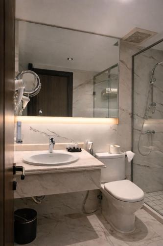 a bathroom with a sink and a toilet and a mirror at LeChateau Boutique Hotel in Jeddah