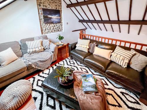 a living room with a leather couch and a table at 3 Bed in Holt oc-1331 in Bodham