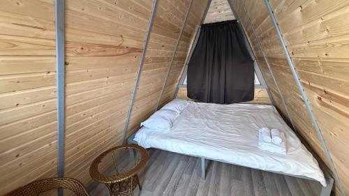 a bed in a tent with two pairs of slippers at Arrow Burabay in Borovoye