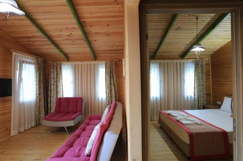 a bedroom with two beds and two chairs in a room at Turnalı Bungalow in Kıranköy