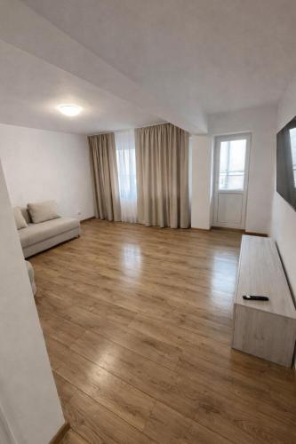 an empty living room with a couch and a table at Ultracentral Modern Apartment Toma Caragiu, Ploiesti in Ploieşti