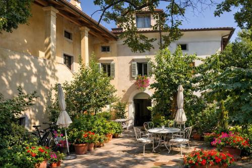 a patio with tables and chairs and flowers in front of a building at Aurisina heart apartment in Aurisina