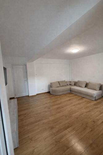a living room with a couch and a wooden floor at Ultracentral Modern Apartment Toma Caragiu, Ploiesti in Ploieşti