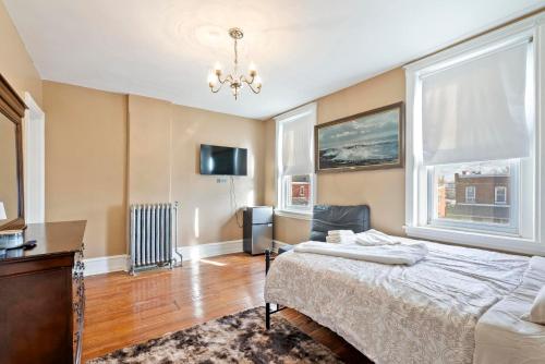 a bedroom with a bed and a desk and two windows at Candlelight Chamber - Private Room with Shared Space in Chester