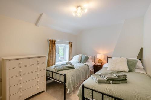 a bedroom with two beds and a dresser at 2 Bed in Aylsham oc-s30931 in Aylsham