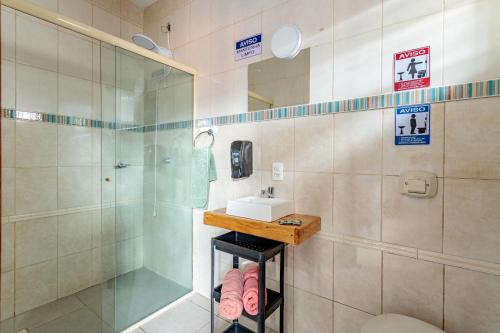 a bathroom with a glass shower and a sink at Casa perto do centro e da Udesc Cefid in Florianópolis