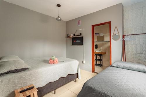 a bedroom with two twin beds and a bathroom at Casa perto do centro e da Udesc Cefid in Florianópolis
