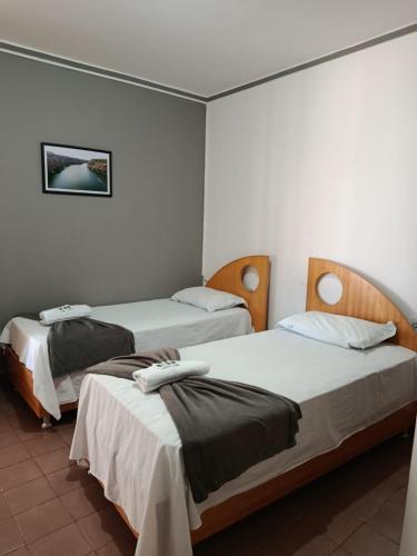 two beds in a room with white walls at China Hotel in Canindé de São Francisco