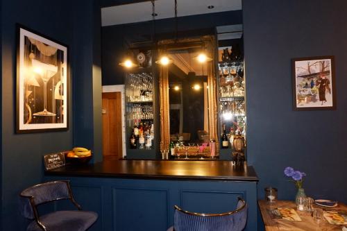 a bar with a mirror and two chairs and a table at Southbank Townhouse in Torquay