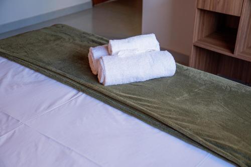 a pair of towels sitting on top of a bed at POUSADA AMORIM in Santo Amaro
